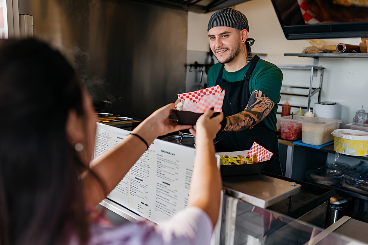 food truck owner handing order to customer